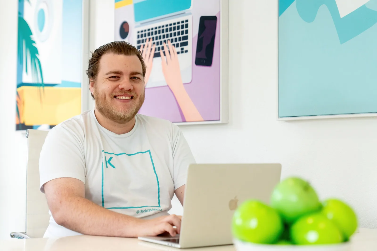 A K.I.S.S team member smiling at his laptop in the Cronulla office